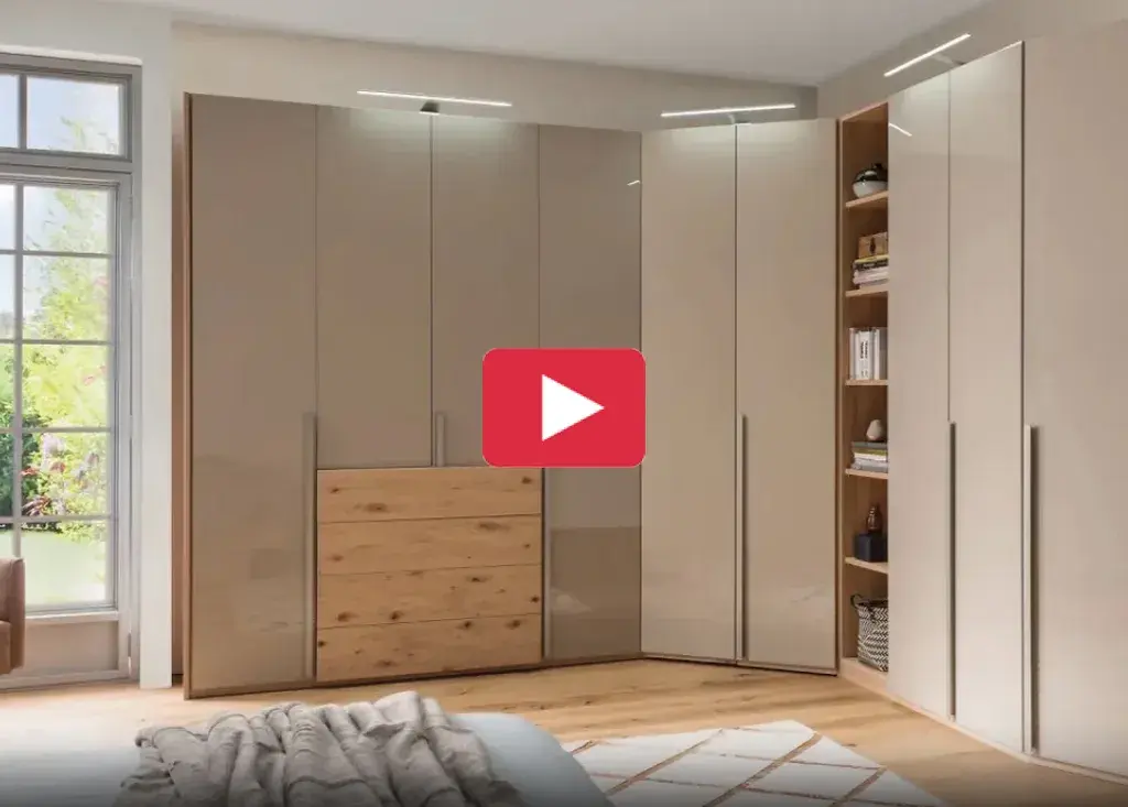 Moderner Eckkleiderschrank mit Hochglanzfront, Holzelementen und integrierter LED Beleuchtung im Schlafzimmer, kombiniert mit offenen Regalfächern für stilvollen Stauraum.